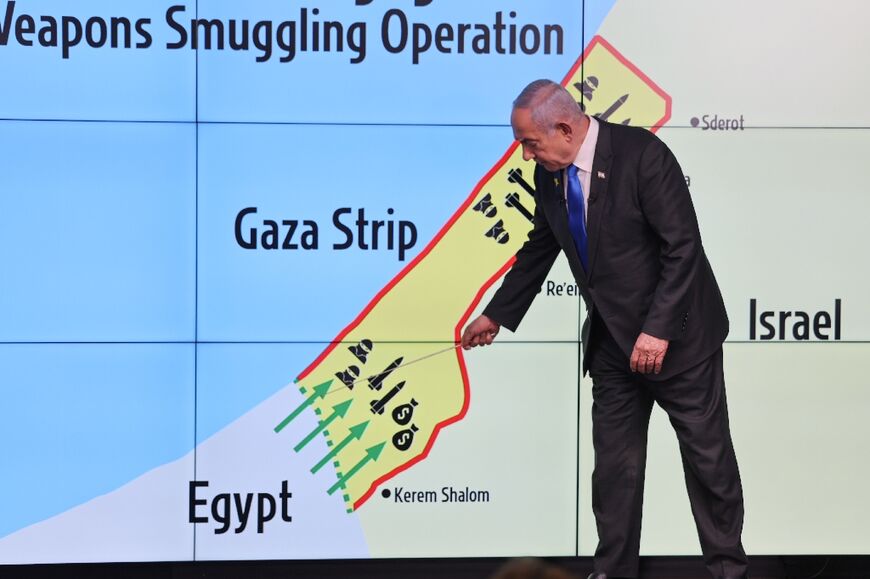 Israel's Prime Minister Benjamin Netanyahu points at the Philadelphi corridor on a map - the strategic area is a sticking point in truce negotiations