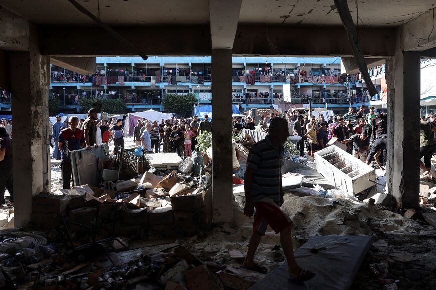 Palestinians survey the Al-Jawni school in central Gaza after an Israeli air strike 