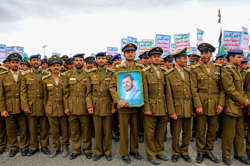 Members of Huthi-affiliated security forces hold a portrait by the movement's leader Abdul Malik al-Huthi at a march in the capital Sanaa on February 16, 2024