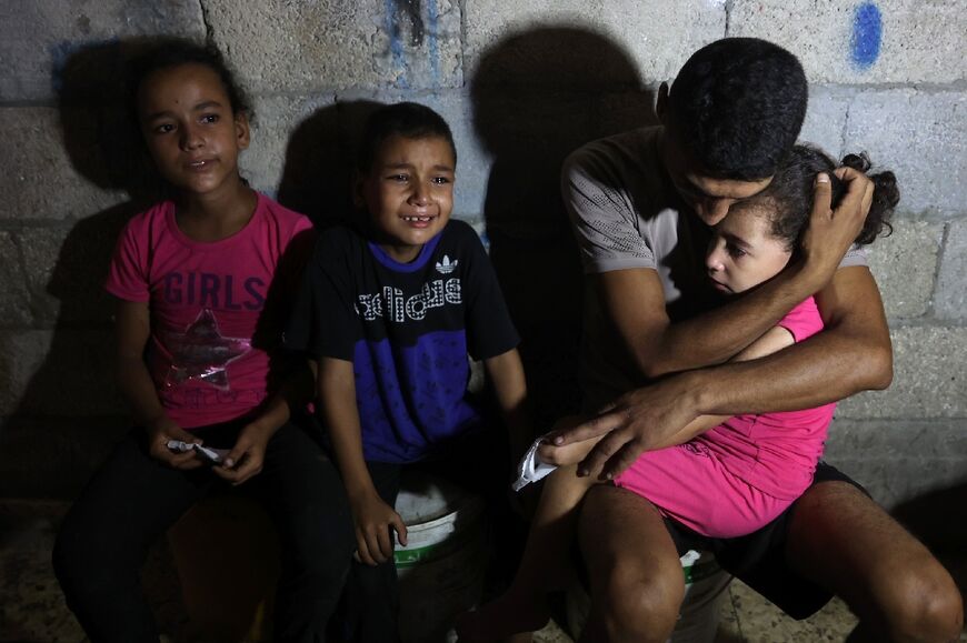 People mourn near the body of a loved one killed during an Israeli strike on the Amr Ibn al Aas school housing displaced Palestinians in Gaza City