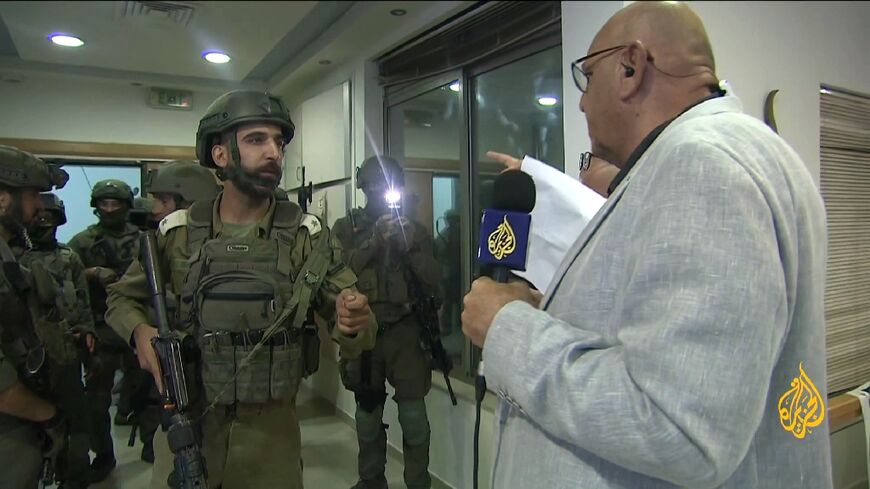 Al Jazeera's West Bank bureau chief Walid al-Omari (R) in a grab from live footage of the raid