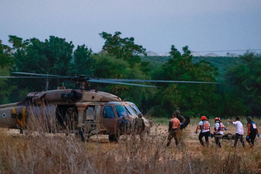 Rescue teams evacuate wounded people near Israel's southern city of Sderot on October 7, 2023