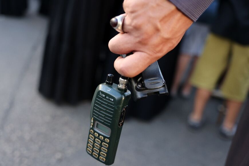 A man in southern Beirut holds a walkie-talkie after he removed the battery as a safety precaution