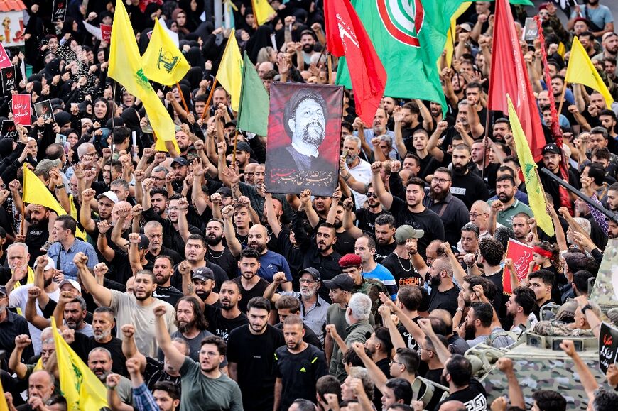 Mourners in Beirut chant slogans during the funeral of people killed in the initial wave of blasts