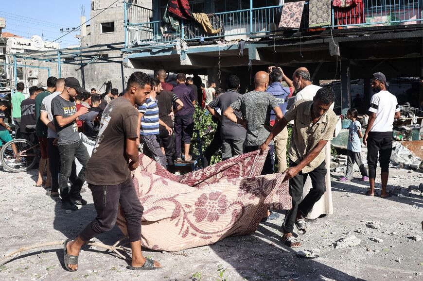 Rescuers use a blanket to transport one of the casualties from the strike, which Israel says targeted Hamas operatives