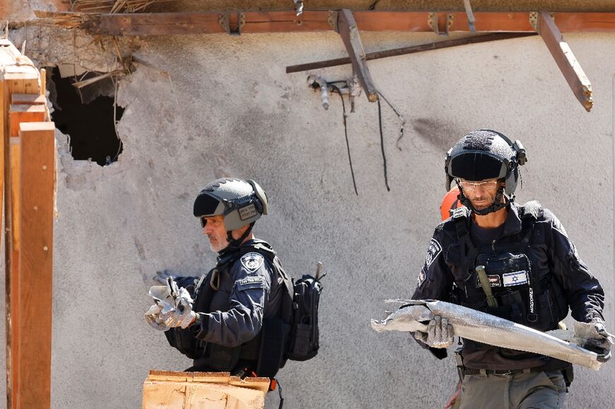 Israeli emergency responders remove remnants of a rocket at the site of a strike, fired from Lebanon, in the northern Israeli city of Safed