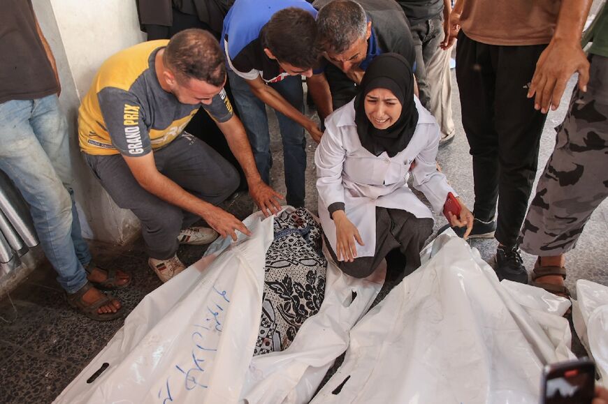 Palestinian physician Najwa Alborno (C) mourns relatives killed in an Israeli strike in Gaza City