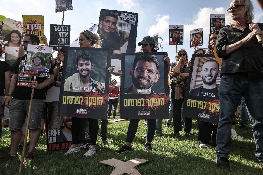 Relatives and supporters of the hostages hold pictures of Hersh Goldberg-Polin (L), Almog Sarusi (C) and Alexander Lubanov outside the prime minister's office in Jerusalem