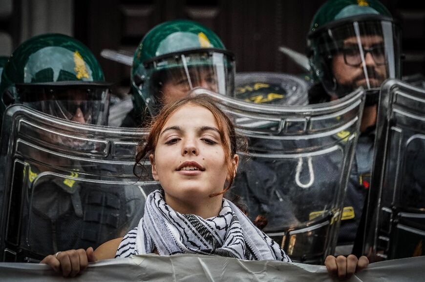 Outside the meeting, some demonstrators carried Palestinian flags and wore the keffiyeh