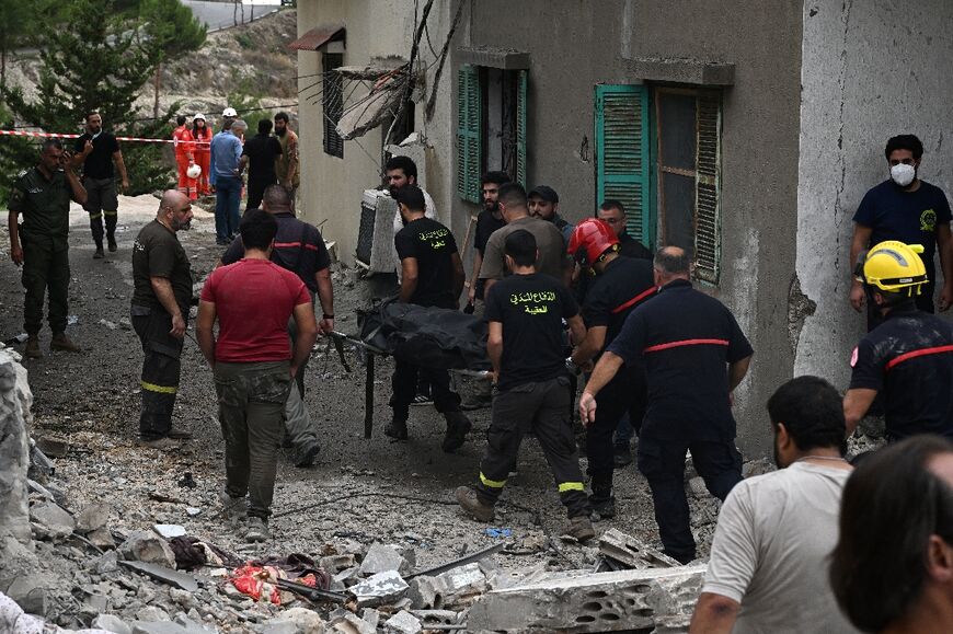 Lebanese rescue workers remove a body from the site of an Israeli air strike on the Mount Lebanon village of Maaysra