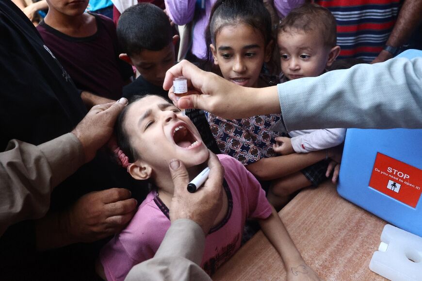 Palestinian children receive drops as part of a polio vaccination campaign in Deir al-Balah in the central Gaza Strip