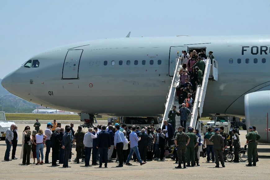 Passengers disembark the first Brazilian government rescue flight from Beirut after arrival at Sao Paulo Air Base 