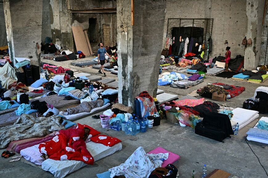 African migrant workers, who fled Israeli bombardment in southern Lebanon, seek refuge at a warehouse turned into a shelter by a group of volunteers, in eastern Beirut