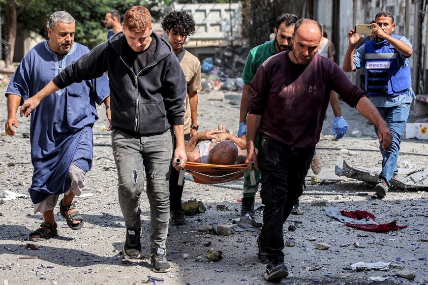 A man rescued from the rubble is carried away on a stretcher