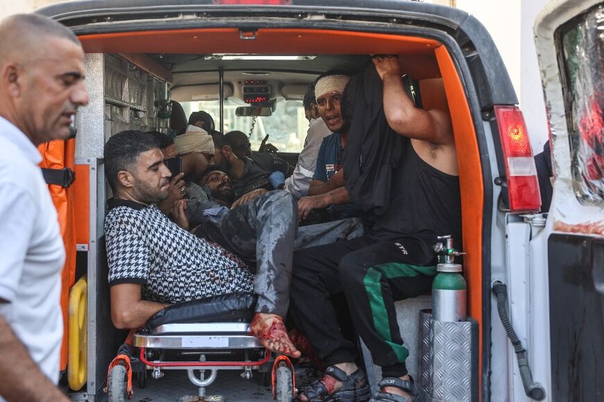 Palestinians injured in Israeli strikes that targeted areas of the northern Gaza Strip arrive in the back of an ambulance to receive treatment at al-Maamadani hospital, Gaza City