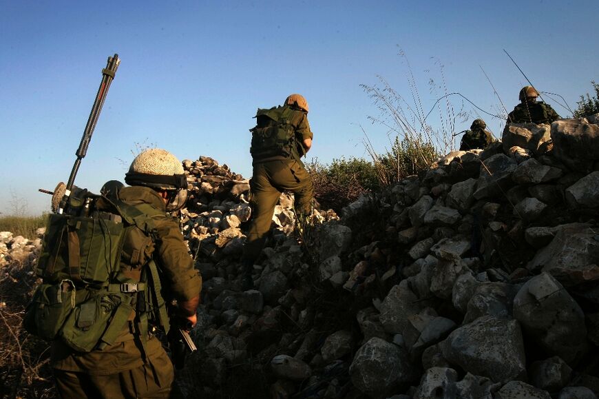 Israeli soldiers patrol along the Lebanese border, near the Israeli town of Avivim, on July 25, 2006 during war against Hezbollah