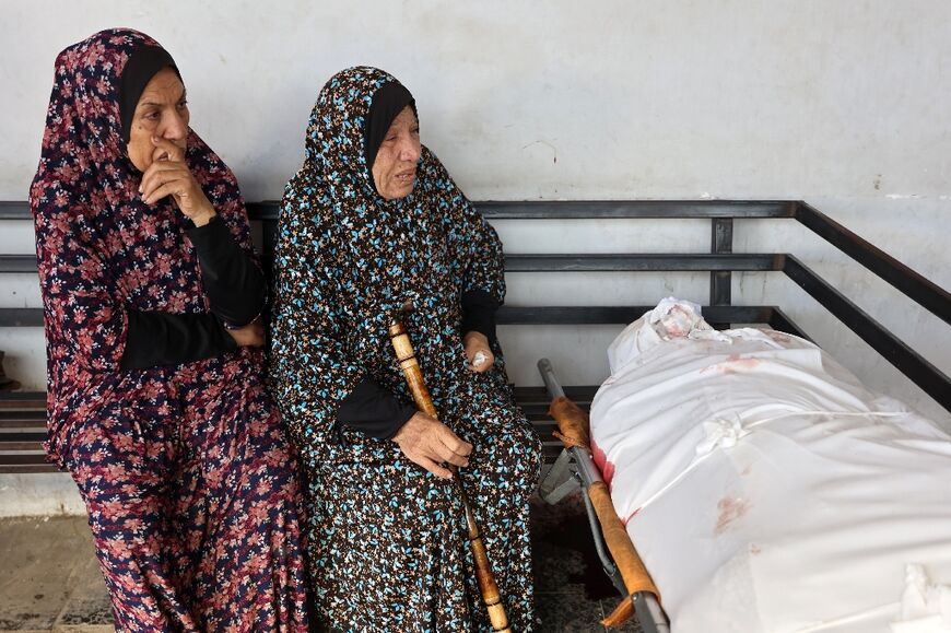 Palestinian women mourn over the bodies of relatives killed in an Israeli air strike on Jabalia