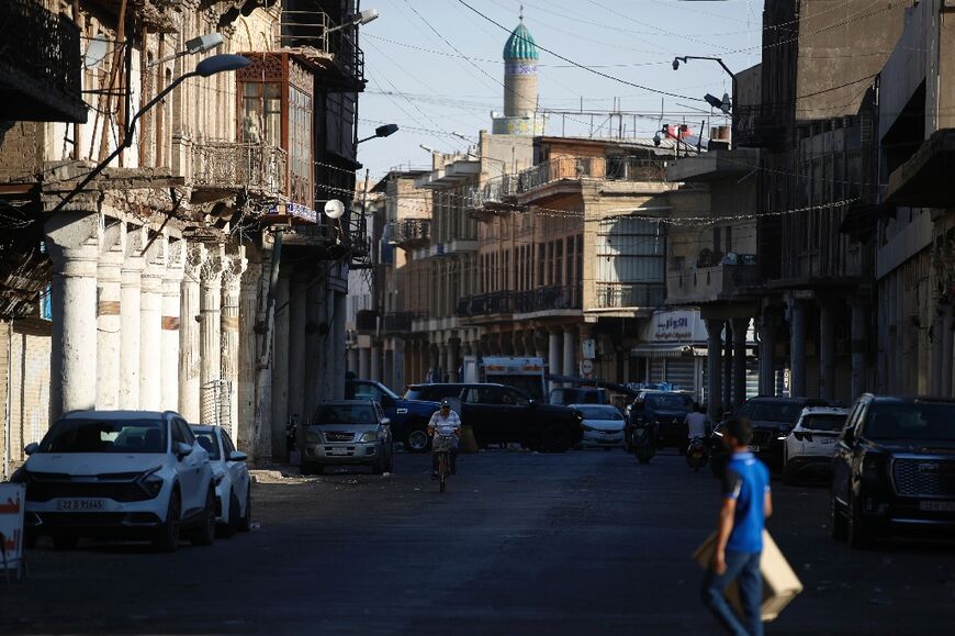 A man walks past historic buildings on Rashid Street in central Baghdad