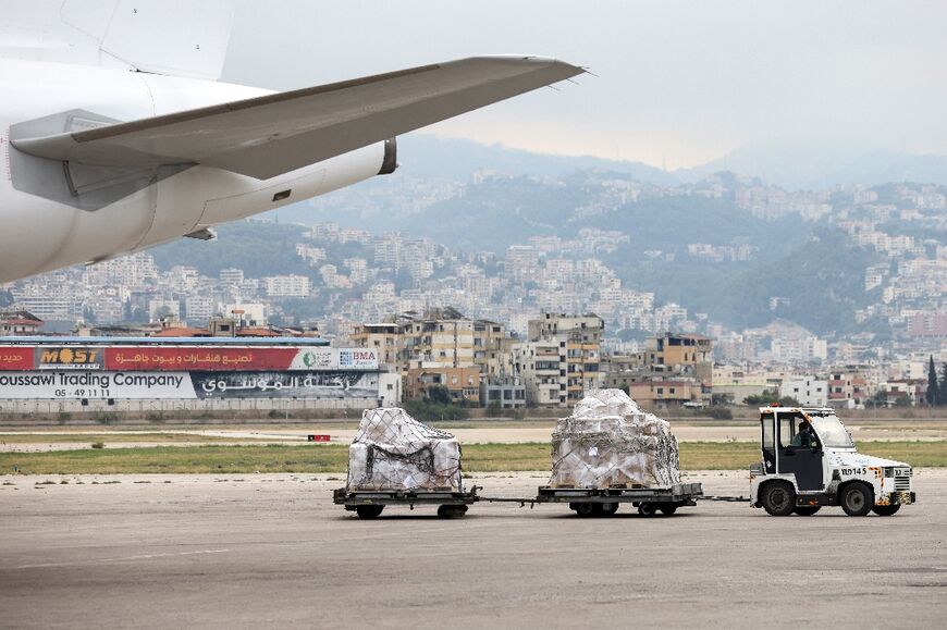 Airport workers transport relief supplies provided by UK Aid and the United Nations children's fund (UNICEF) at Beirut International airport 