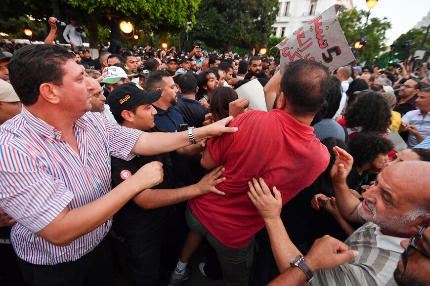 Anti-Saied demonstrators scuffle with security forces during a protest in Tunis on October 4