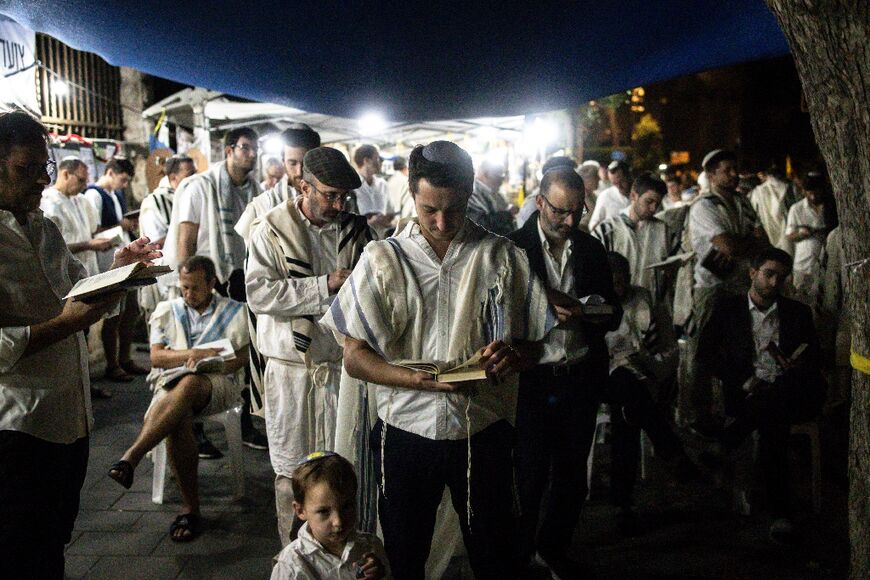 Relatives and friends of Israelis taken hostage by Hamas militants in Gaza block a road to pray for their release at the start of the Jewish holiday of Yom Kippur in Jerusalem 