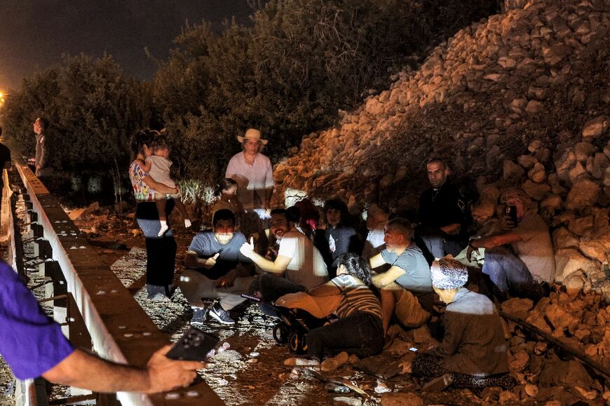 People take cover under a bridge along a highway in northern Israel