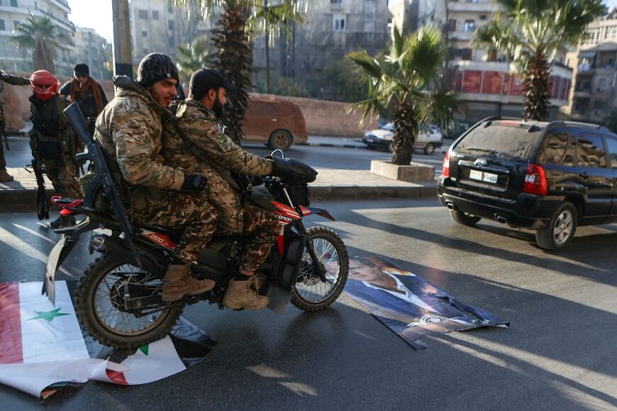 Anti-regime fighters in the centre of Aleppo, Syria's second city, ride over a picture of President Bashar al-Assad 