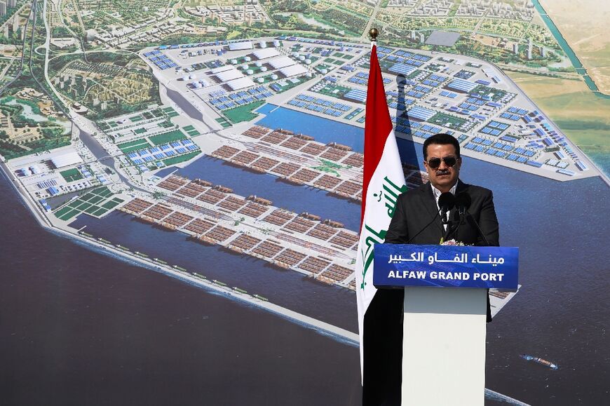 Iraqi Prime Minister Mohammed Shia al-Sudani speaks at the inuaguration ceremony in front of an image of what the planned new port may look like when completed