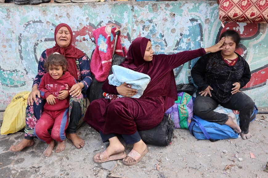 Palestinians at the courtyard of a school-turned-shelter following an Israeli strike in Gaza City's Al-Shati refugee camp