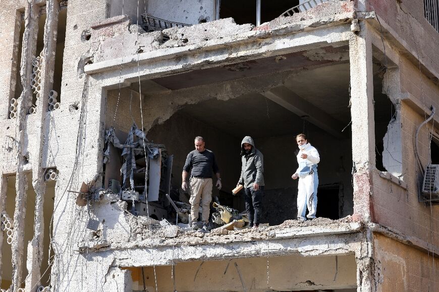 Residents check a flat heavily damaged by Israeli bombardment in the southern Lebanese city of Tyre 