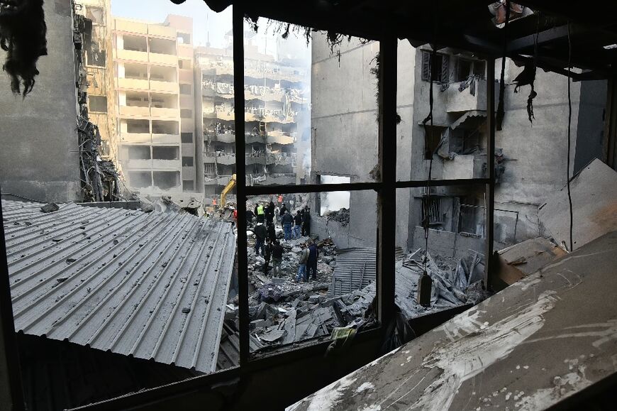 A picture taken from inside a damaged building shows rescuers sifting through rubble after the overnight strike in Basta