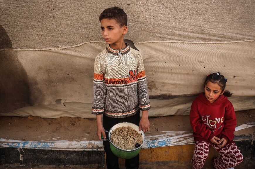 Palestinian children collect food aid at Bureij refugee camp in central Gaza