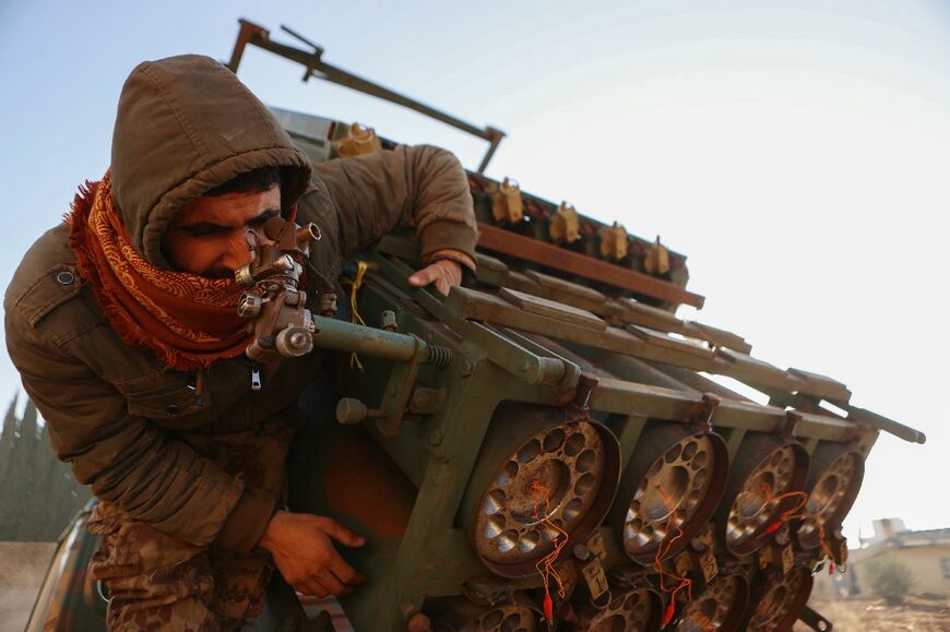 A fighter inspects a seized Syrian Army rocket launcher in Khan al-Assal district, which jihadists and their Turkish-backed allies took over in an offensive against Syria's army in Aleppo province