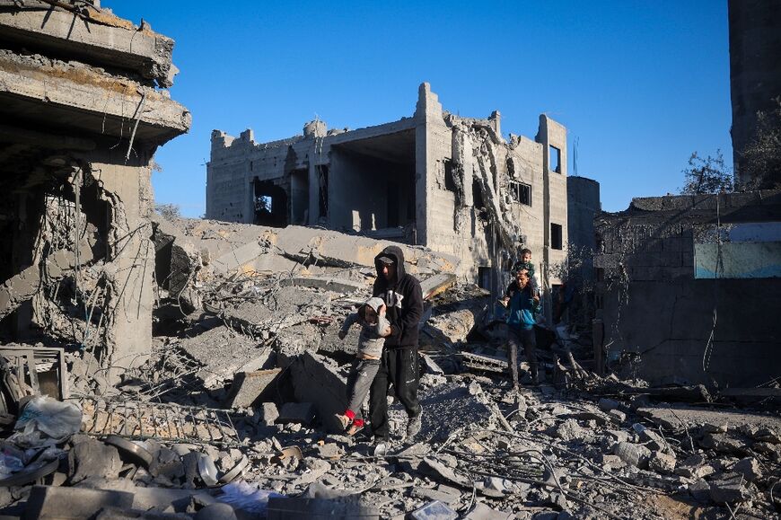 Men carry boys through the rubble of a house in central Gaza destroyed in an Israeli strike.