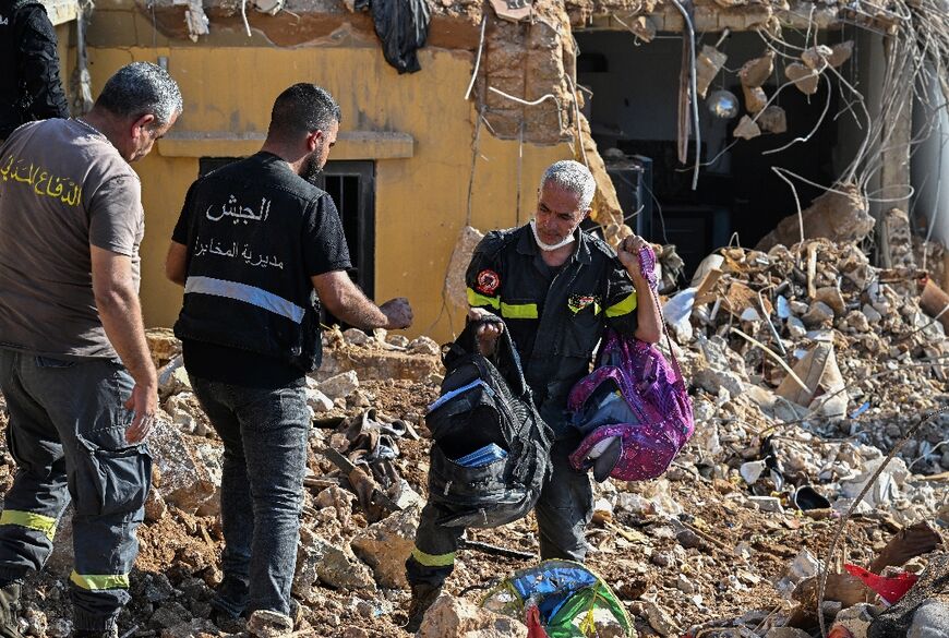 Lebanese emergency crews recover school bags and other personal belongings from the rubble before clearing it