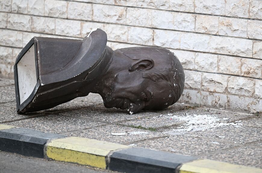 A toppled bust of Assad's father nd predecessor, Hafez, lies discarded on the pavement outside the defence ministry complex.