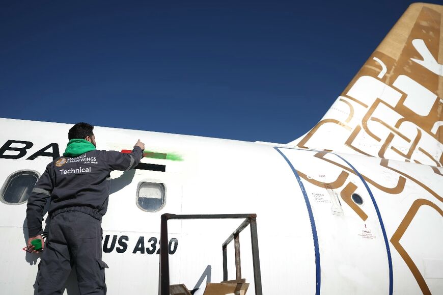 A man painted the flag of the Syrian revolution on an aircraft at Damascus international airport 