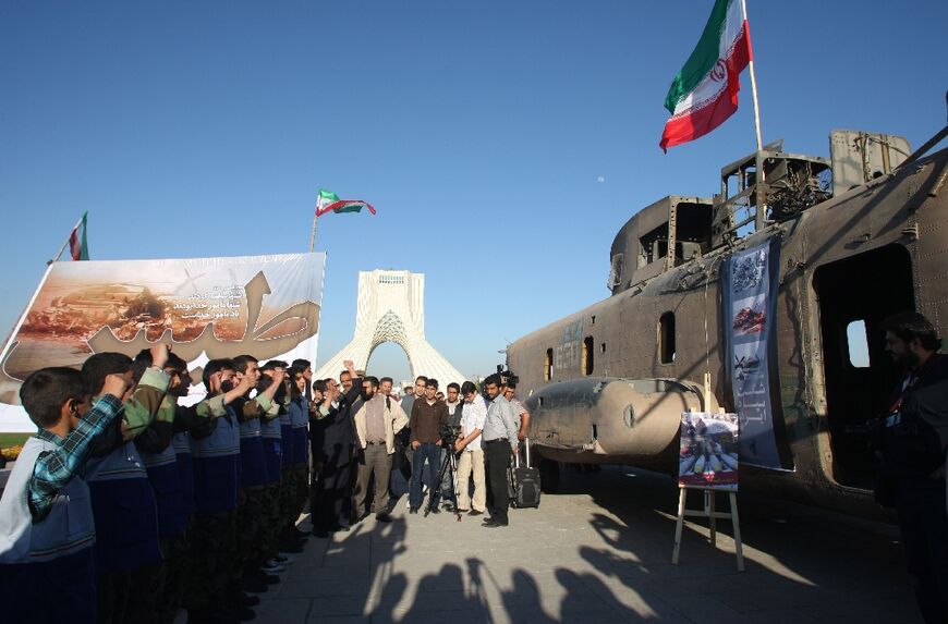 Iranians gather around the wreckage of a captured US CH-53 Sea Stallion helicopter during a ceremony in Tehran's Azadi Sqare on April 25, 2010 to mark the 30th anniversary of the failed US mission to release American embassy staff taken hostage 