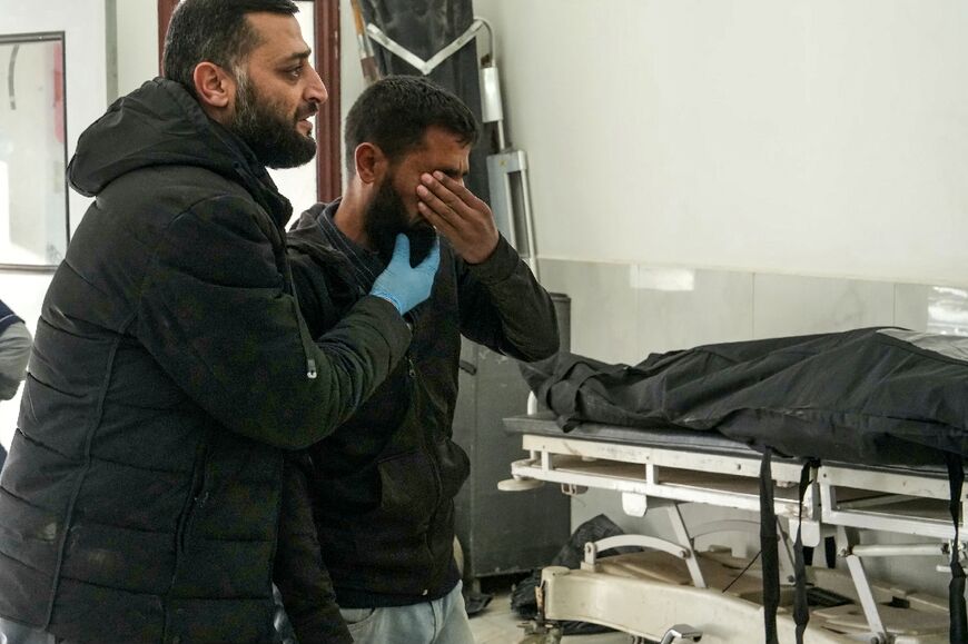 A man reacts next to body at a hospital in Syria's rebel-held city of Idlib, after what a war monitor called Russian air strikes 