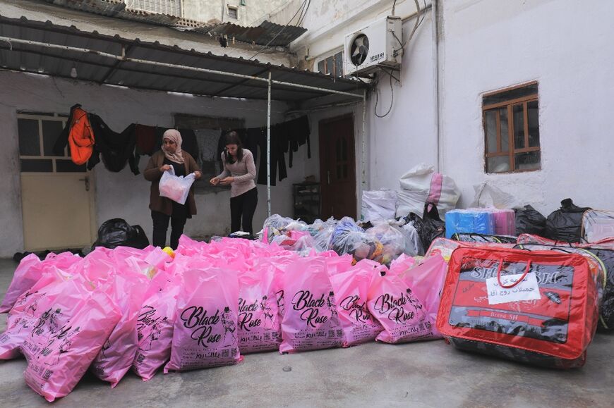 Syrian Kurds collect and sort clothes in the northeastern city of Qamishli for distribution to Kurds displaced from towns in the Aleppo countryside