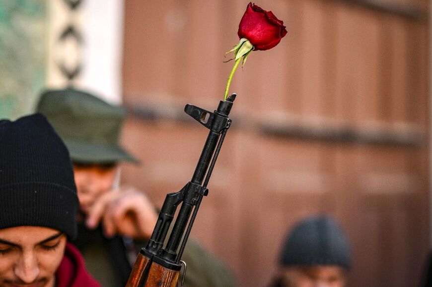 A rose placed in the barrel of a gun of a Syrian rebel fighter in Damascus