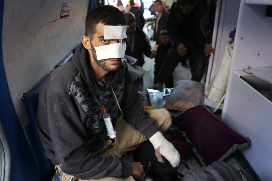 A wounded Palestinian in the back of an ambulance arrives at Al-Shifa Hospital in Gaza City, after transfer from Kamal Adwan Hospital