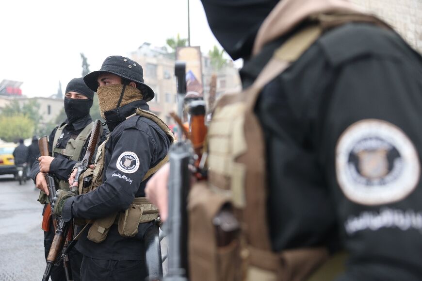 Syrian security forces of the transitional government stands guard in a street in the capital Damascus