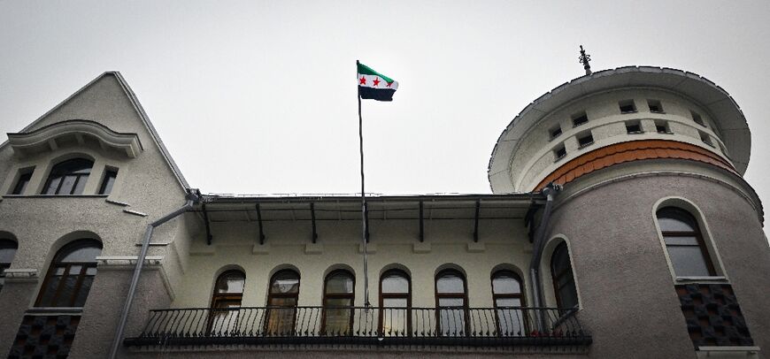 The flag of Syria's opposition waves over the country's embassy in Russia, a key ally of Assad