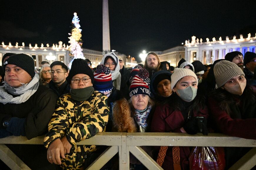 Faithful gather in front of the basilica at St Peter's square during the Christmas Eve mass in the Vatican 