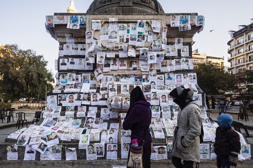 Posters of missing people hang on a monument in central Damascus