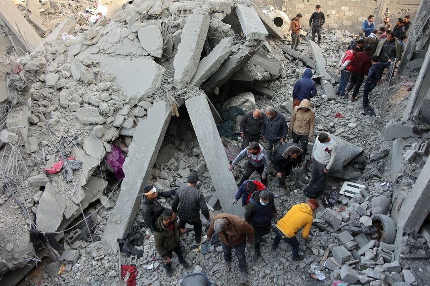 Civilians check the site of an Israeli strike in Jabalia, in the central Gaza Strip