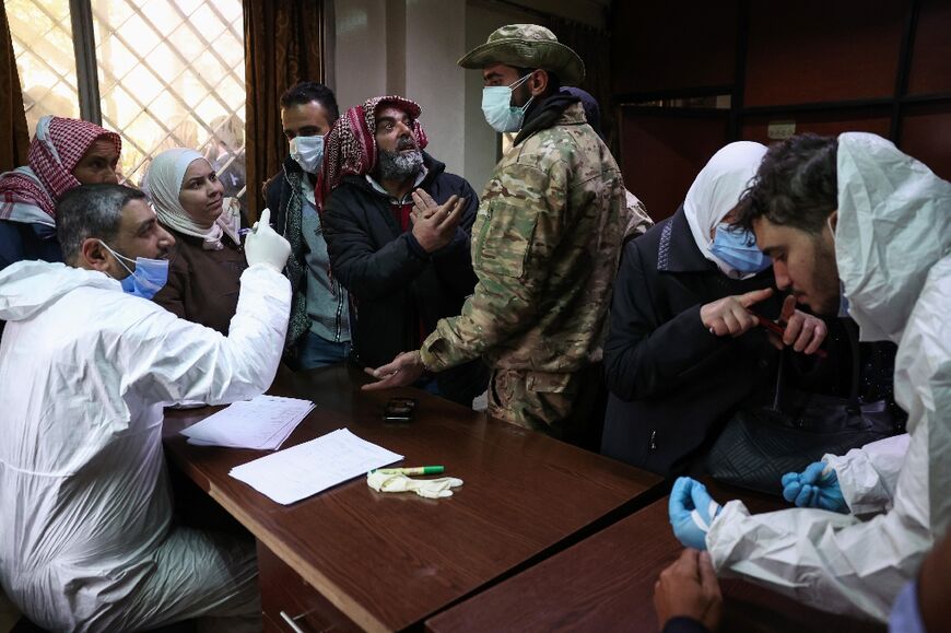 Syrians searching for missing relatives talk with the new authorities at a Damascus morgue.