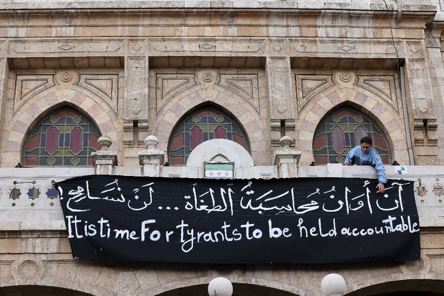 A banner calling for accountability hangs from the balcony of the Hijaz train station in Damascus