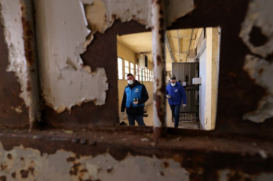 Members of the United Nations High Commissioner for Refugees, UNHCR, check now-empty cells inside Saydnaya prison